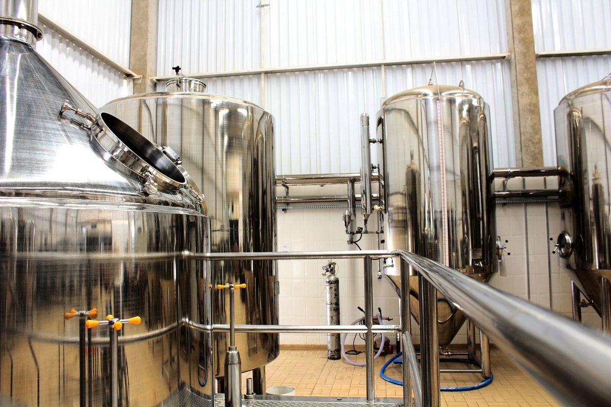 Stainless-steel production tanks on a manufacturing floor (stock photo)